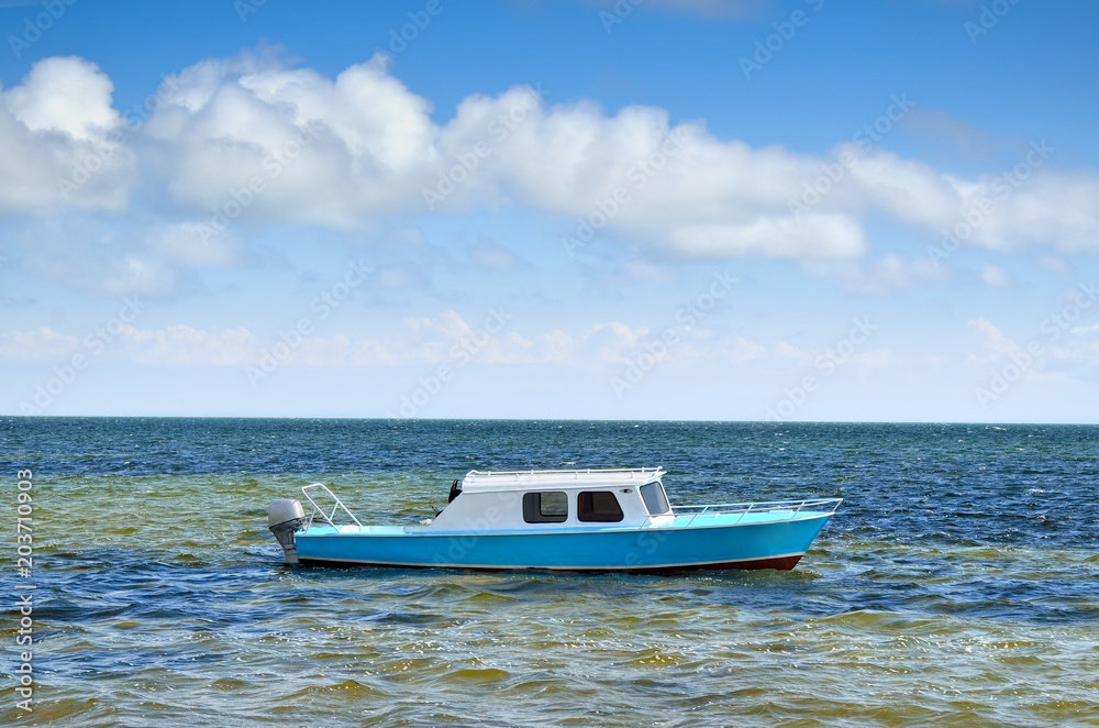 Motor boat on sea waves against the blue sky