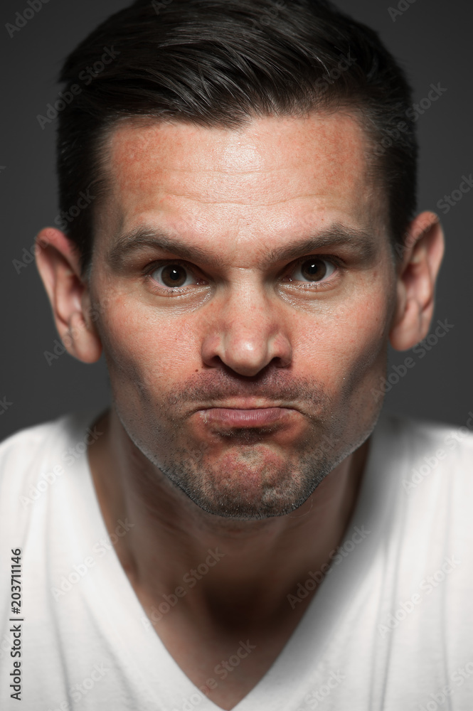 Close-up portrait of angry caucasian man on gray background Close-up portrait of angry caucasian man on gray background
