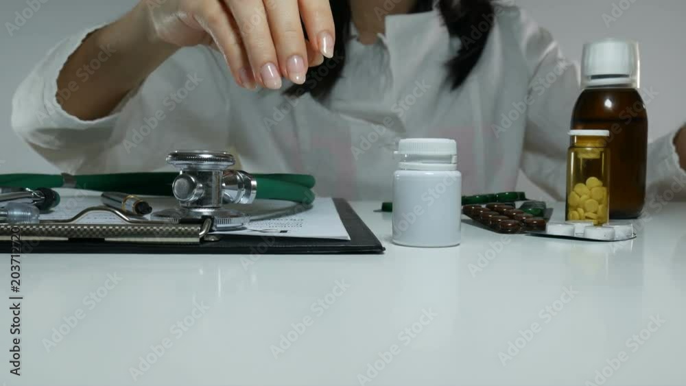 female doctor demonstrates a white jar of pills female doctor demonstrates a white jar of pills