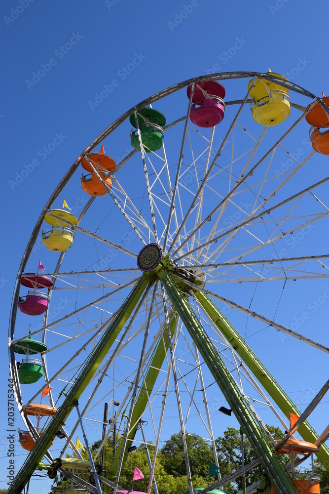 Colorful small ferris wheel against bright blue sky. Colorful small ferris wheel against bright blue sky.