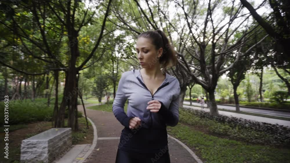 Beautiful young athletic girl in sportswear makes warm up, workout in a green summer sport park. Sport fitness wellness video shooting of sexy female model, camera advance Beautiful young athletic girl in sportswear makes warm up, workout in a green summer sport park. Sport fitness wellness video shooting of sexy female model, camera advance