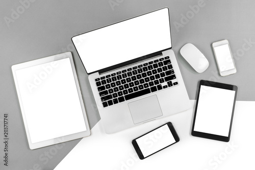 Office table with laptop computer, digital tablet, smartphone and mouse on isolated pure white background. Laptop and tablet mockup concept. (Monitor clipping path)(Selective Focus)