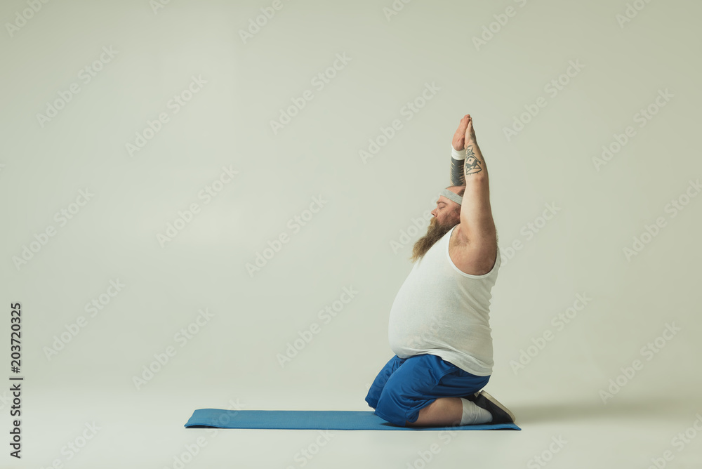Fotografie Male doing yoga on mat