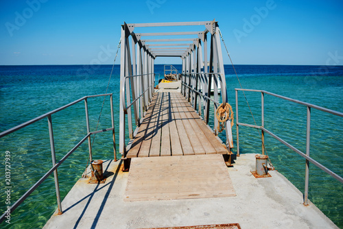 Swimming ladder from stainless steel for descent into sea water on pier. Silent bay ideal for children swim and play photo