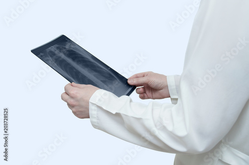 Doctor in white lab coat holds x-ray in white on white background