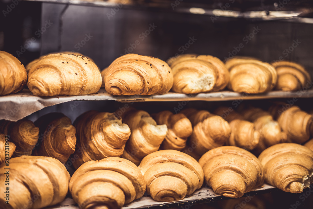 Fresh baked croissants on a showcase in a bakery shop