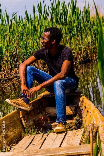 Young black man posing on the boat on the Eber lake in Turkey. Eber lake is located between two Turkish cities Afyon and Konya photo