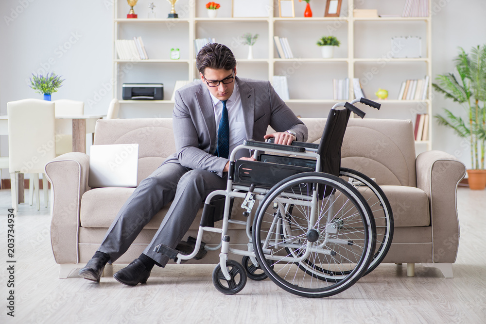 Dsabled businessman on wheelchair working home Dsabled businessman on wheelchair working home