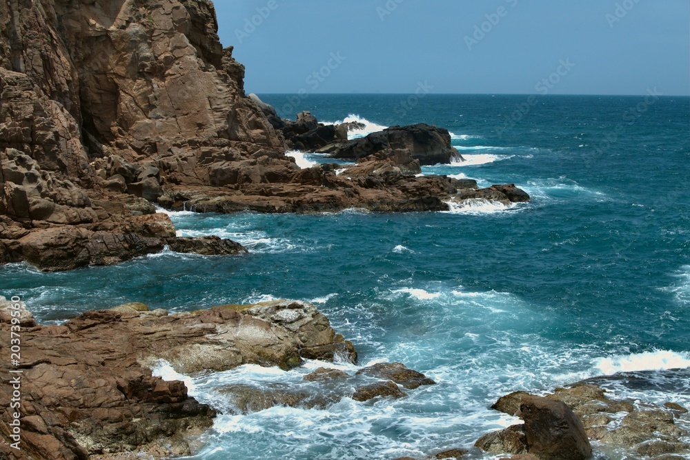 bright blue sea with sharp cliffs