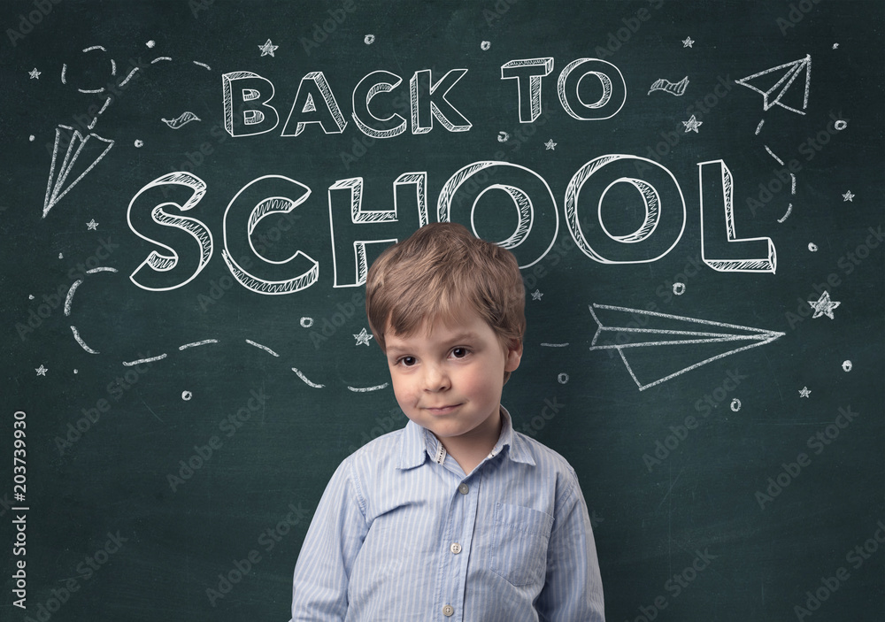 Adorable little boy with blackboard and back to school concept