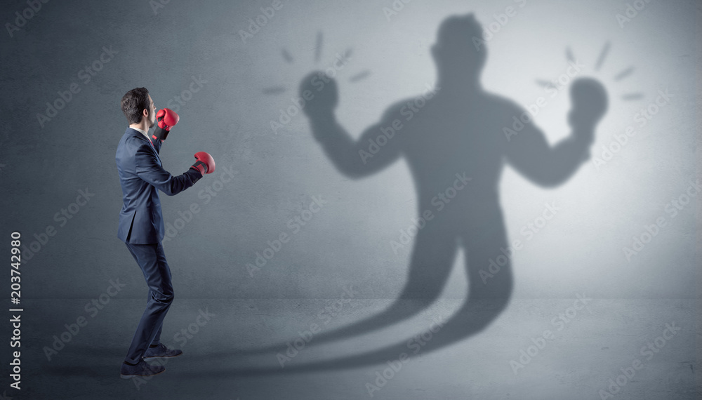 Businessman trying to fight with his unarmed shadow
Businessman trying to fight with his unarmed shadow