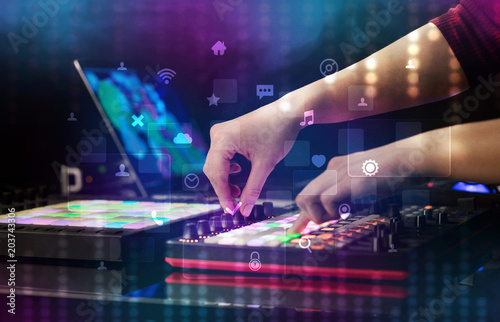 Hand mixing music on dj controller with social media concept icons 