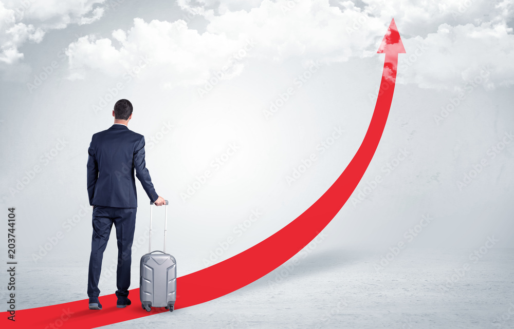 Young businessman with back leaving on the red arrow carpet to the skies with luggage on his hand
Young businessman with back leaving on the red arrow carpet to the skies with luggage on his hand