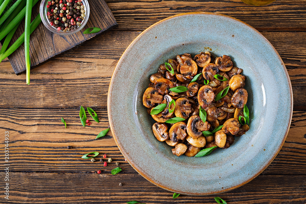 Baked mushrooms with soy sauce and herbs. Vegan food. Top view Baked mushrooms with soy sauce and herbs. Vegan food. Top view