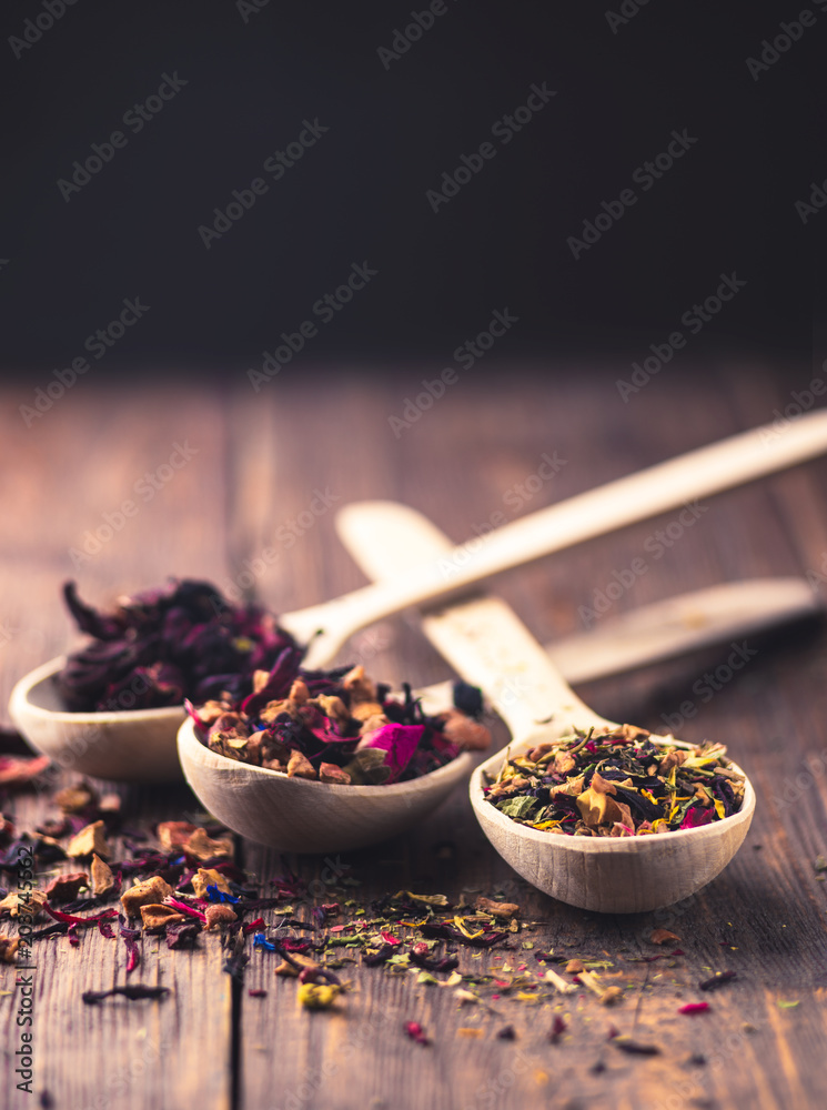 Set of different tea in wooden spoons, rustic style, wooden background. Set of different tea in wooden spoons, rustic style, wooden background.