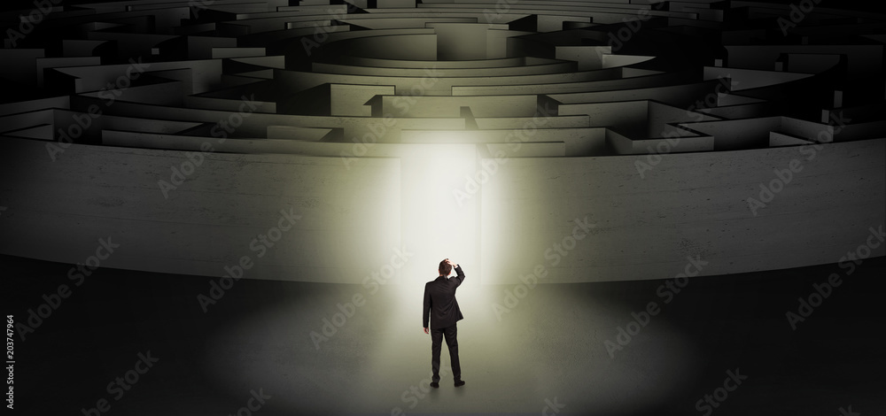 Businessman getting ready to enter a concentric labyrinth with lighted entrance concept
Businessman getting ready to enter a concentric labyrinth with lighted entrance concept