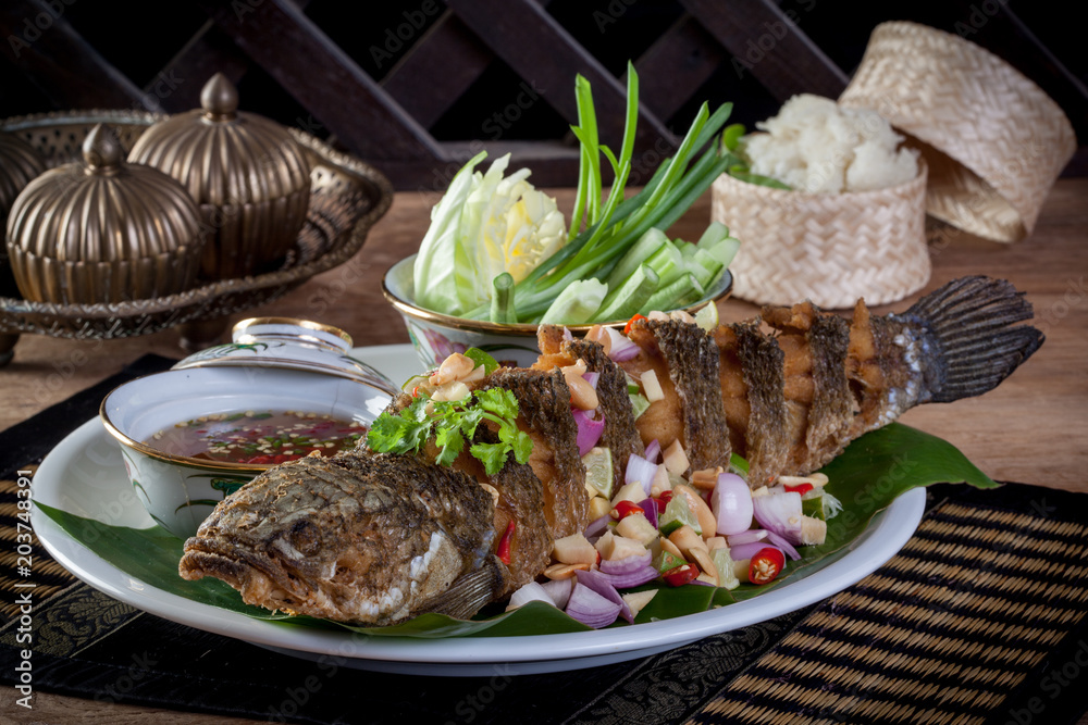 fried fish with herb and spicy sauce, thai food.