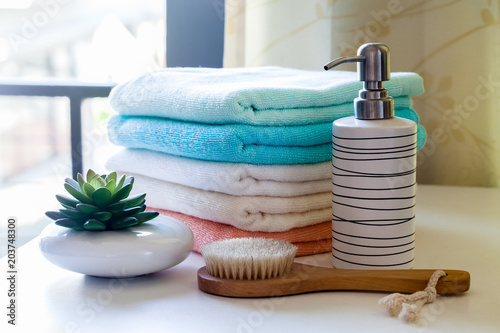 Stack of bath towels with toothbrushes on table