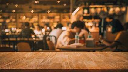Wood table top with blur of people in coffee shop or (cafe,restaurant )background