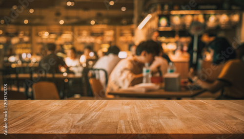 Wood table top with blur of people in coffee shop or (cafe,restaurant )background