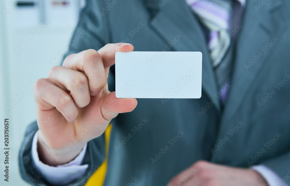 Businessman in grey suit and a pink shirt shows business card with copy space, shallow dept of field. Businessman in grey suit and a pink shirt shows business card with copy space, shallow dept of field.