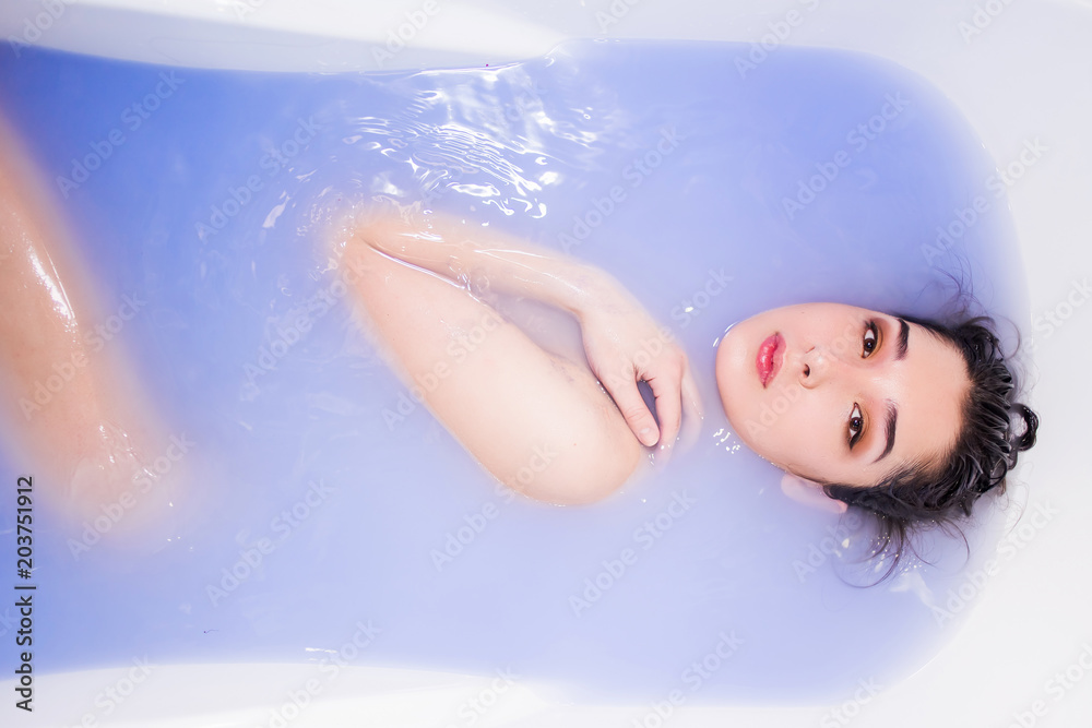 Attractive naked girl enjoys a bath. Spa treatments for skin rejuvenation