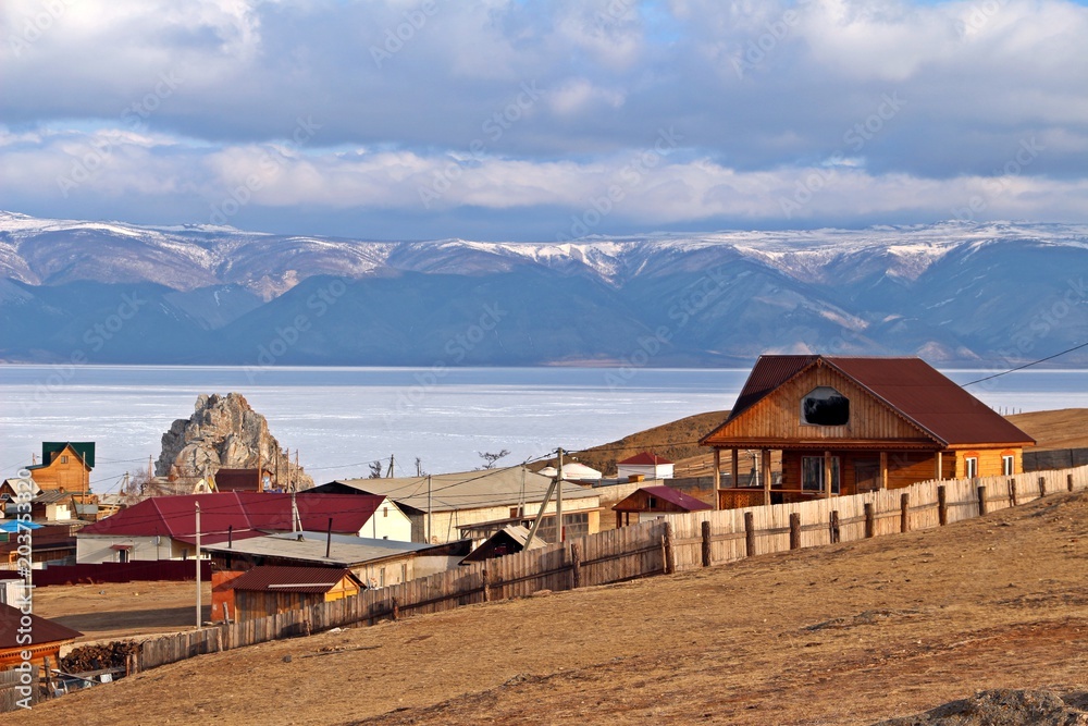 Khuzhir city with Shamanka Rock and beautiful mountainious behind Baikal lake in late winter