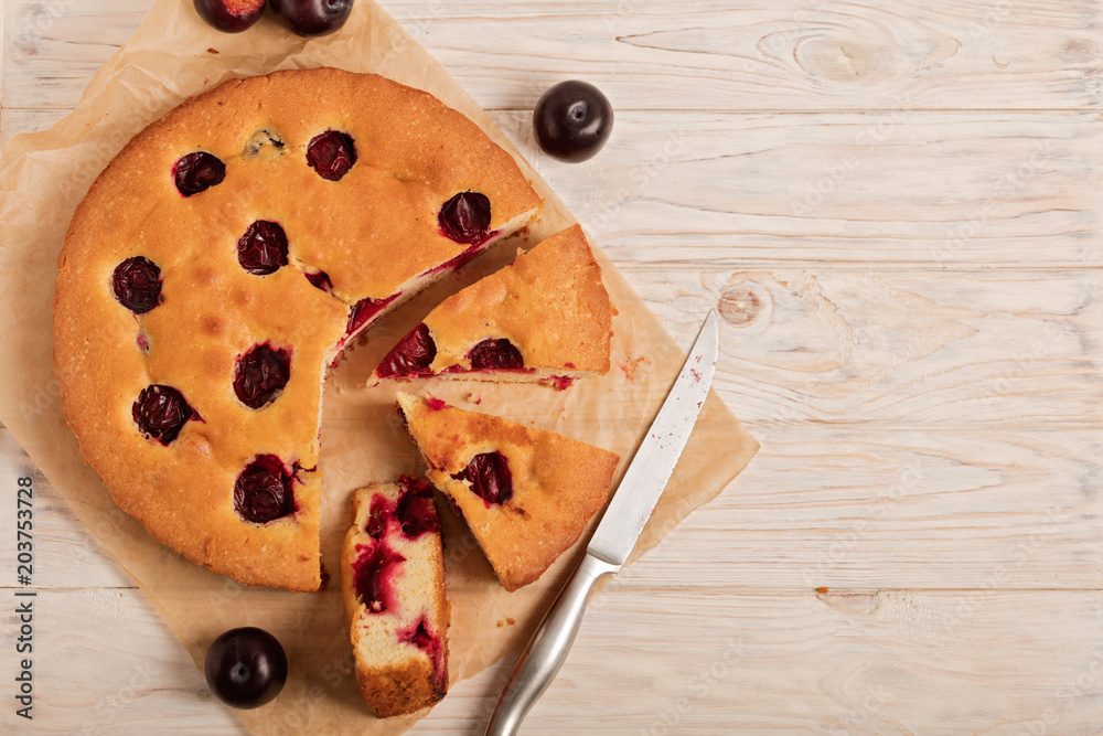 Home plum pie on baking paper. Home plum pie on baking paper.