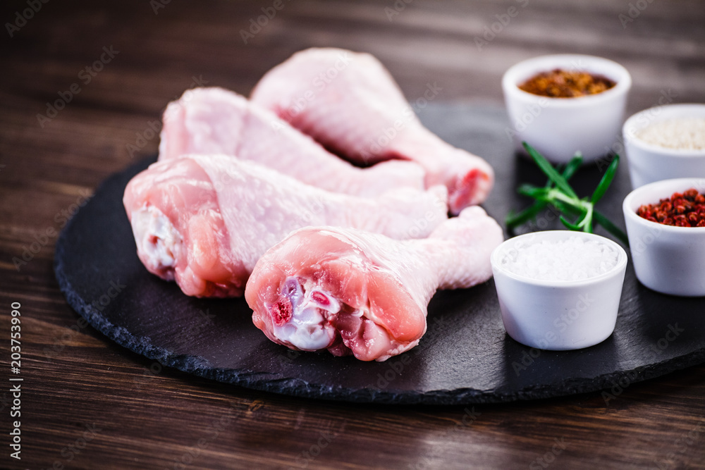 Raw chicken drumsticks on wooden background Raw chicken drumsticks on wooden background