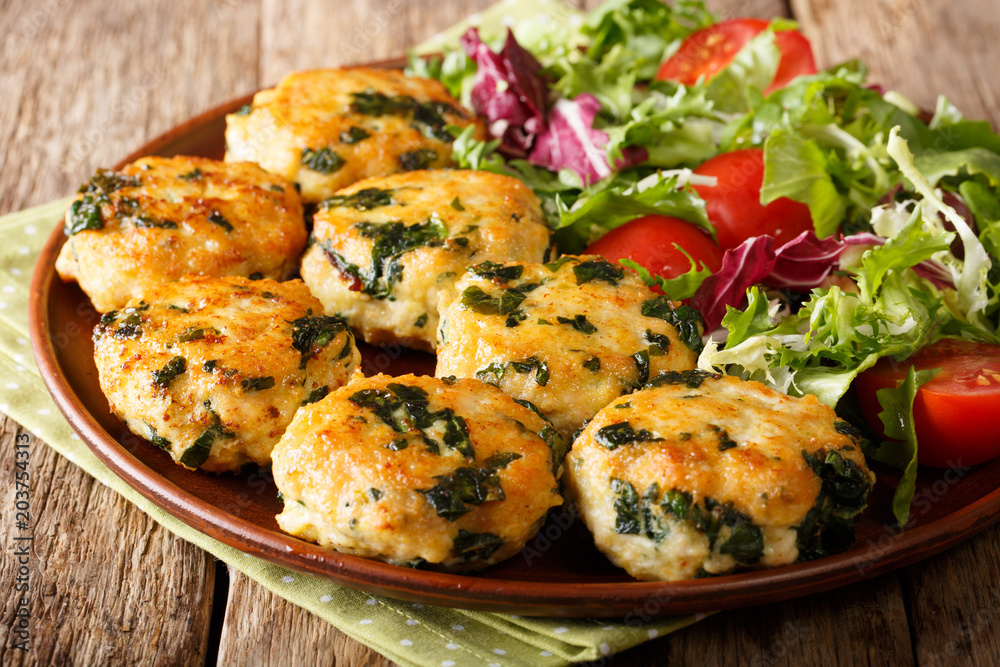 Dietary tasty meat balls with spinach and vegetable salad close-up on a plate. horizontal Dietary tasty meat balls with spinach and vegetable salad close-up on a plate. horizontal