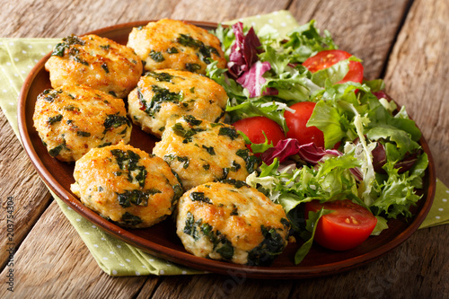 Homemade chicken balls with spinach and cheese and vegetable salad close-up on a plate. horizontal