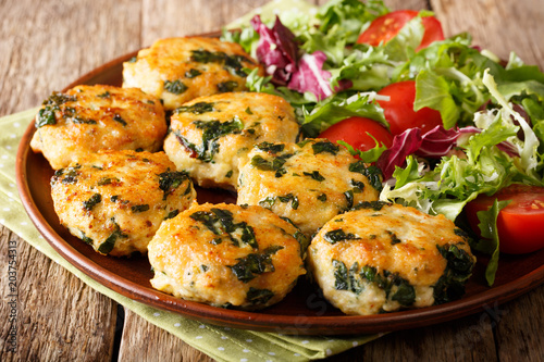 Dietary tasty meat balls with spinach and vegetable salad close-up on a plate. horizontal