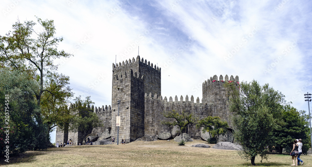 Guimaraes, Portugal. August 14, 2017: exterior of the royal stone castle built in the 11th century by the king of Portugal named Afonso Henriques, with ramparts and fortified battlements