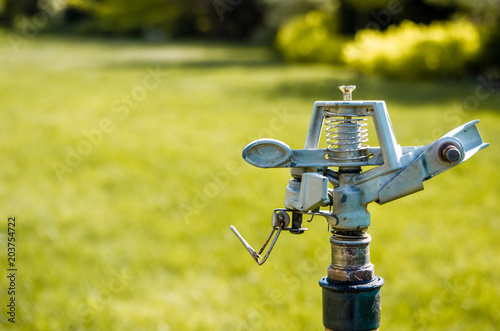 Sprinkler on the grass in the garden, copy space