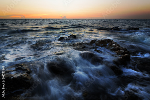 Fototapeta Naklejka Na Ścianę i Meble -  wave at the sea on the rock with sunset sky