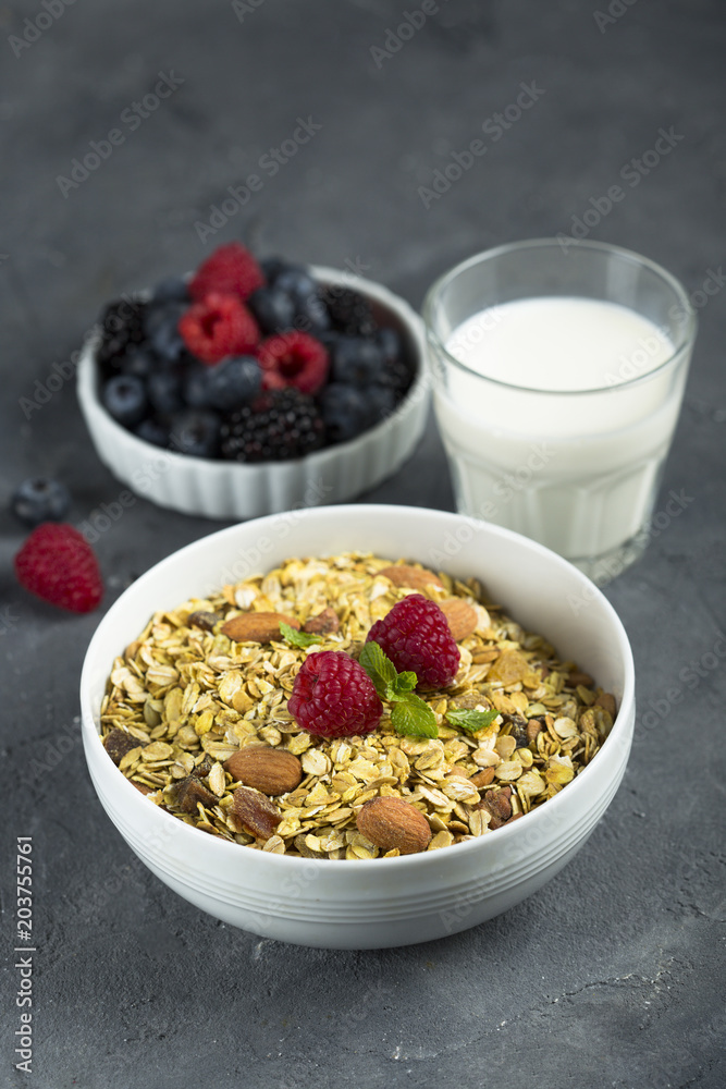 Homemade granola with fresh berries and mint, served with milk Homemade granola with fresh berries and mint, served with milk