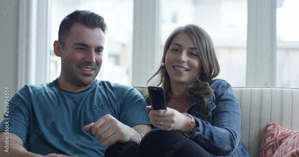 Young couple watching tv -woman takes remote control Young couple watching tv -woman takes remote control