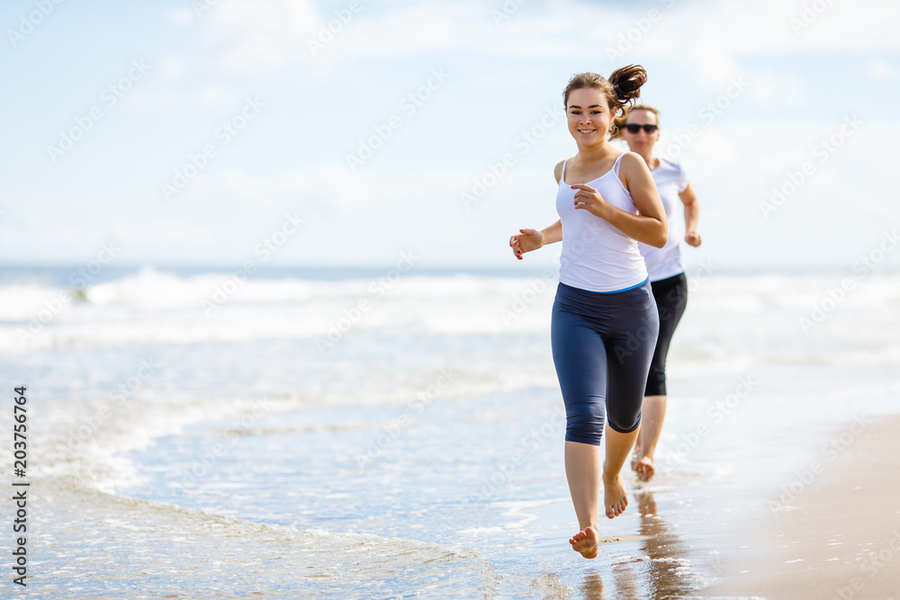 Two women running on beach Two women running on beach