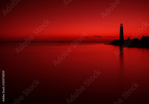 Obraz na płótnie Sea Landscape In Dark Red Tones With The Silhouette Of A Sunken Ship And An Old Lighthouse. Seascape In Red Color. Artistic Scene Under The Name Bloody Mary: Sunken Tanker At Sunset Of The Day. w salonie