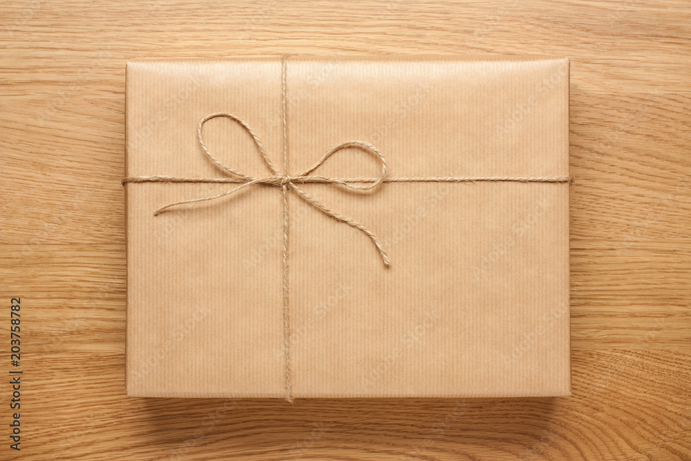 Big gift box wrapped in kraft paper on wooden table Big gift box wrapped in kraft paper on wooden table