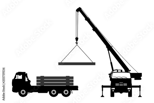 The crane loads the road plates onto the car.