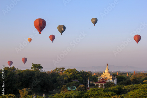 Hot air balloons riding over temples and stupas at sunrise in Bagan. Myanmar