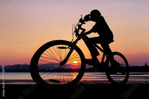 Fototapeta Naklejka Na Ścianę i Meble -  People cycling at the beach twilight time