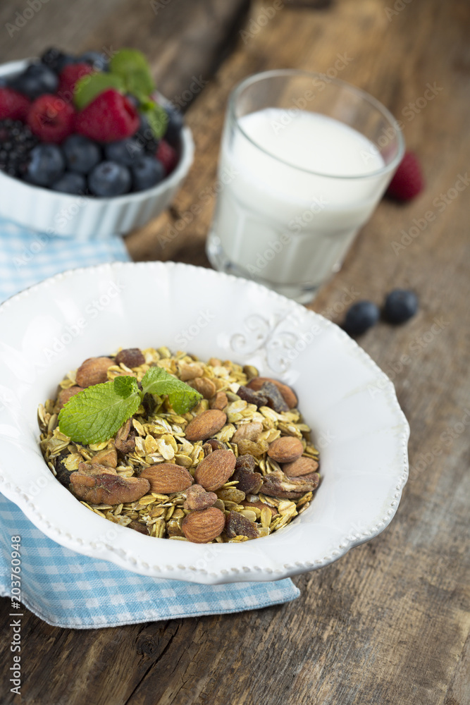 Homemade granola with fresh berries and mint, served with milk Homemade granola with fresh berries and mint, served with milk