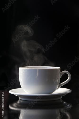 Steaming coffee or tea cup on dark background