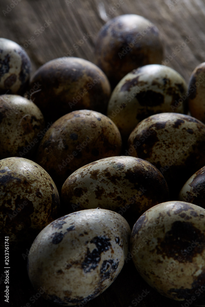 Spotted quail eggs arranged on the background of old wooden boards, with copy-space, selective focus. Spotted quail eggs arranged on the background of old wooden boards, with copy-space, selective focus.