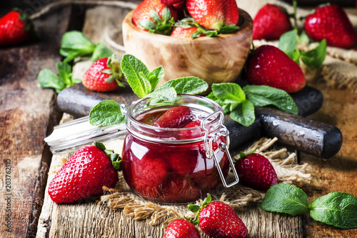 Strawberry jam, vintage wood background, selective focus