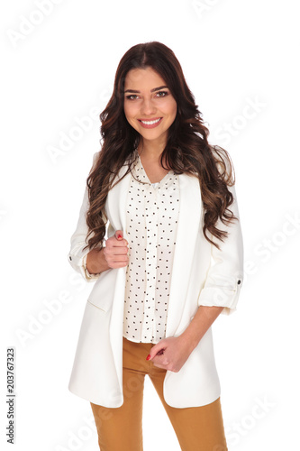 portrait of smiling businesswoman standing while holding her jacket collar