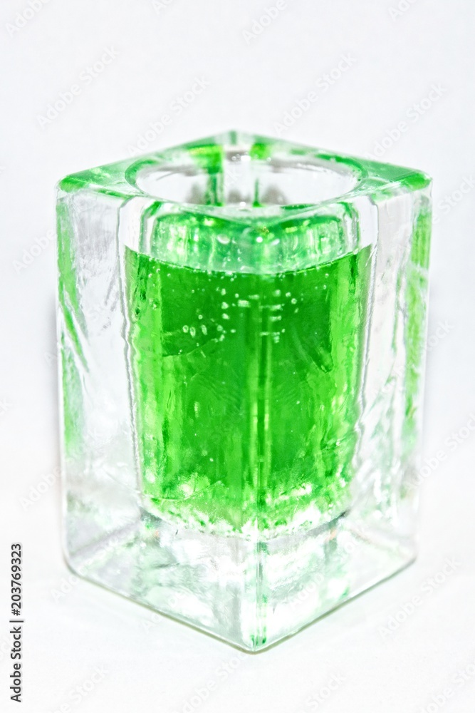 Liquid of poisonous bright color in a glass transparent vessel on a light background
Liquid of poisonous bright color in a glass transparent vessel on a light background