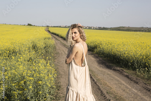 Sexy back of a curly woman in a narutal landscape.